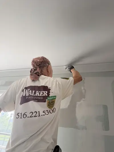 Painter in a Walker Painting shirt cutting in a ceiling line