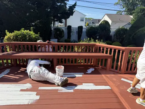 Walker Painting crew staining a backyard deck on Long Island