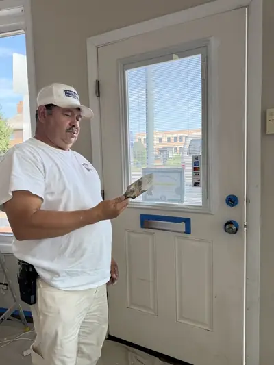 Painter working on the trim around a front door