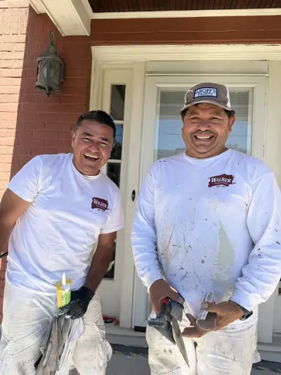 Two Walker Painting crew members laughing at the front door before work