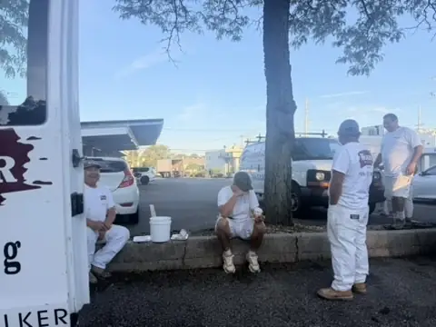 Crew members taking a moment together beside the van between stops